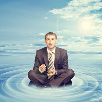 Businessman sitting in lotus position on cloud with oil lamp and looking at camera