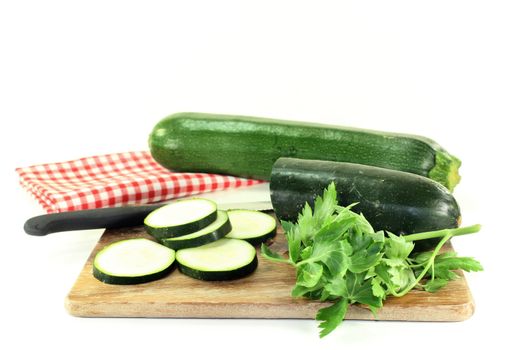 green, raw zucchini in front of white background