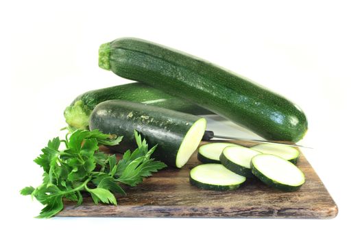 green, raw zucchini in front of white background