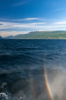 rainbow on a lake Garda with mountains as background. Garda, Italy