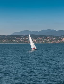 Sail boat on a lake with mountains as a backgroun. Garda, Italy