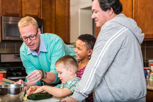 Happy gay dads with their children in the kitchen