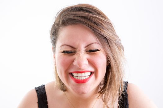 Close up Face of a Blond Woman in Toothy Laugh with Eyes Closed, Facing at the Camera, on a White Background.