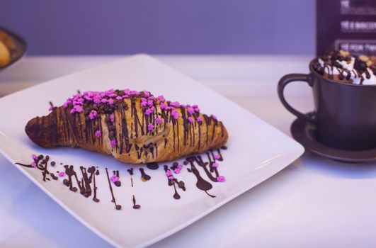 Close up of croissant with chocolate and candies
