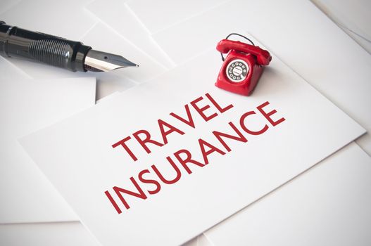 Small telephone on top of travel insurance business cards 