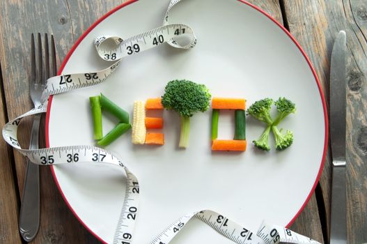 Detox text on a plate made from various vegatables including broccoli, spring onions and carrots