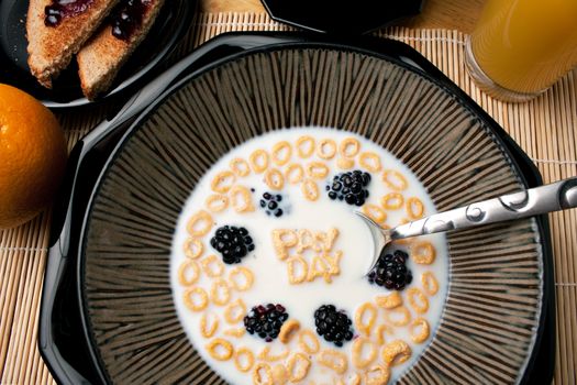 The words PAY DAY spelled out of letter shaped cereal pieces floating in a milk filled cereal bowl.