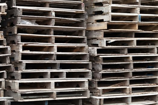 Piles of wooden pallets ready for breaking up and recycling into firewood kindling or DIY projects.