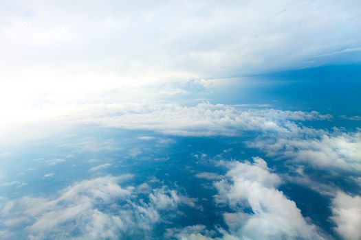 Aerial view of the blue skies and horizon with fluffy clouds and the earth below shot over Tennessee USA.