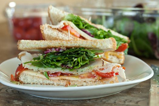 Simple turkey sandwich on honey wheat bread with lettuce and tomato.