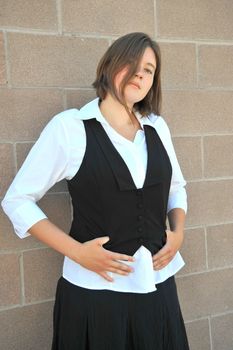 Female nanny posing against a wall outside.