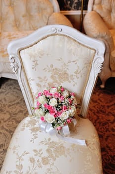 bridal bouquet lying on the chair.