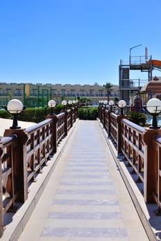 beautiful bridge with wooden railings and lamps.