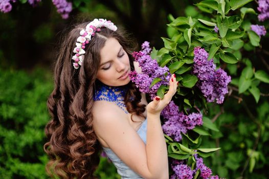 Beautiful young woman in blooming garden in spring.