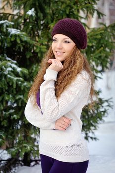 Portrait of beautiful girl in winter near the Christmas tree on the street.