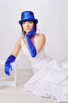 Frightened, surprised the bride in blue gloves and hat.
