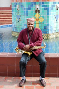 Muslim male jazz musician with his saxophone outdoors.