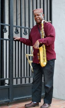 Muslim male jazz musician with his saxophone outdoors.