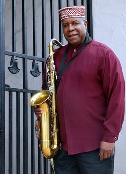 Muslim male jazz musician with his saxophone outdoors.