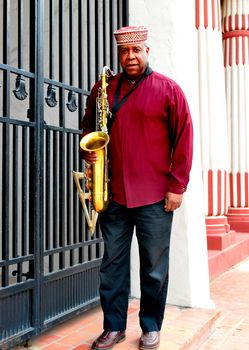 Muslim male jazz musician with his saxophone outdoors.