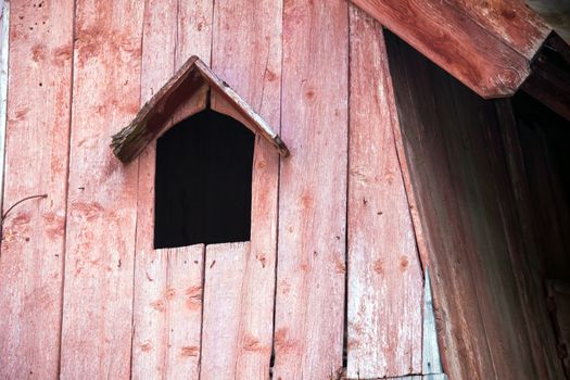 Turda, Romania - June 23, 2013: Typical pink bird house on a wooden roof in Turda city, Romania