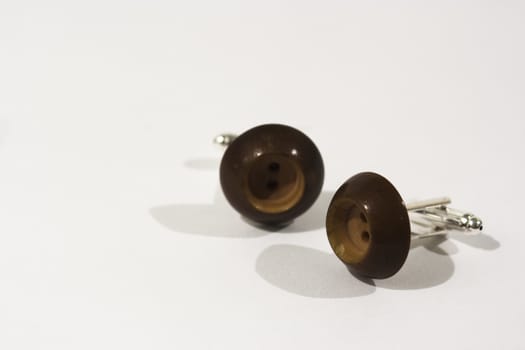 Pair of button cufflinks set on a white background
