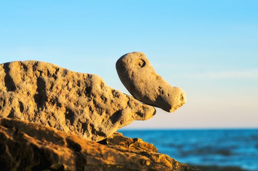 Balancing of stones on the boulder at the seashore