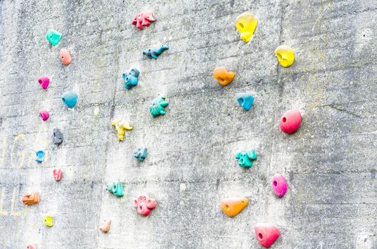 Detail climbing wall at an amusement park with climbing aids.