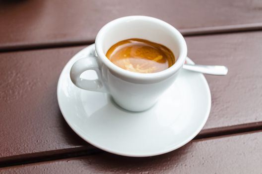 White coffee, espresso cup on a brown wooden table.