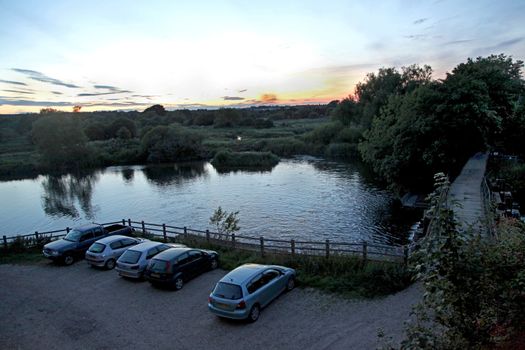 A sunset in the countryside with a lake