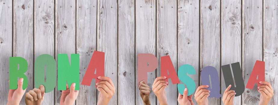 Hands holding up bona pasqua against wooden planks