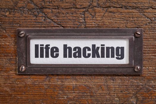 life hacking  tag - file cabinet label, bronze holder against grunge and scratched wood