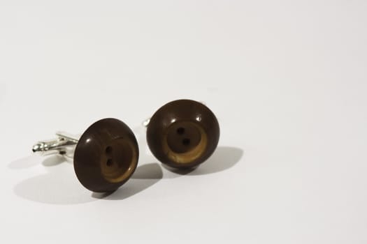 Pair of button cufflinks set on a white background
