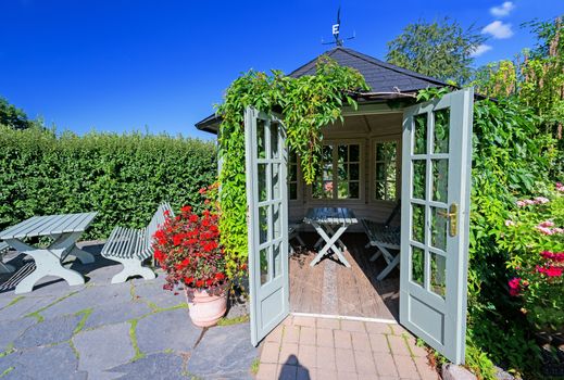 Outdoor wooden gazebo at sunset on summer