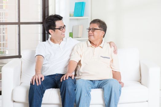 Asian senior father and adult son having conversation at home. Family living lifestyle.