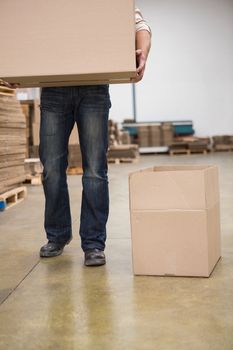 Low section of worker carrying box in the warehouse