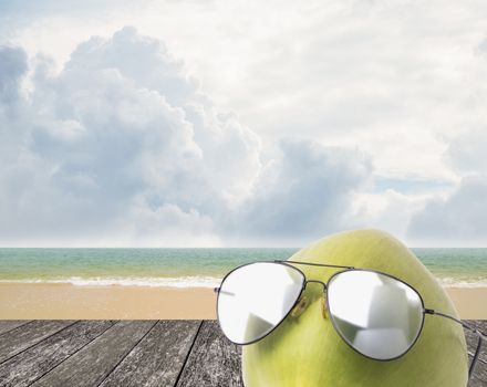 Coconut wear sunglasses beside beach, Summer concept