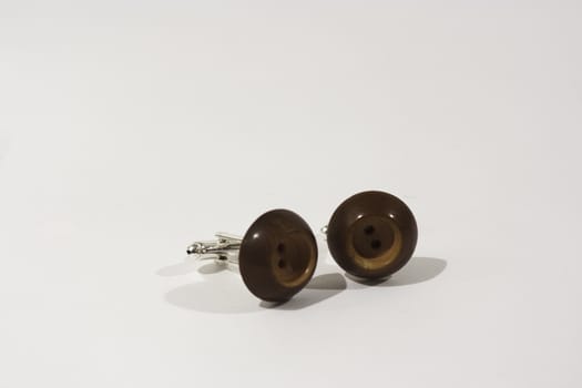 Pair of button cufflinks set on a white background
