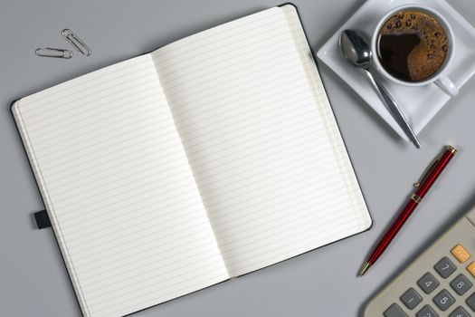 Take a memo - Notepad and coffee cup on an office worktop.