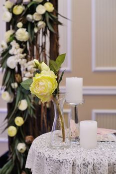 Beautiful white roses on wedding decorated table.