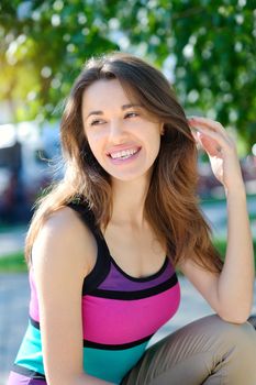 Beautiful young woman outdoors in summer park