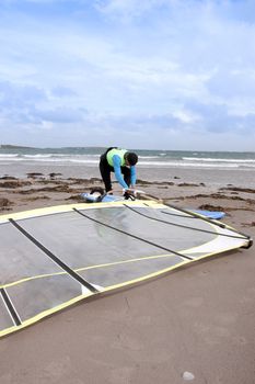 windsurfer getting equipment ready on the beach in the maharees county kerry ireland