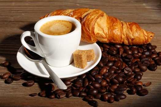 Coffee and croissants on wooden table shallow dof