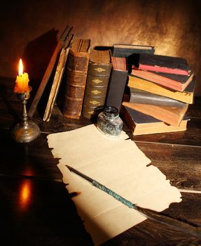 Pile of the old books and a quill 