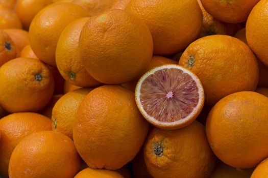 single sliced half blood orange inside oranges.