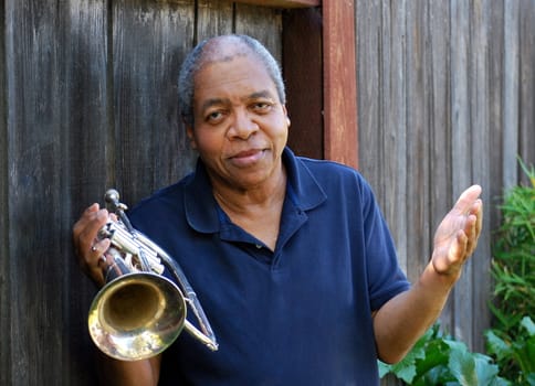 African american jazz musician with his flugelhorn outside.