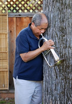 African american jazz musician with his flugelhorn outside.