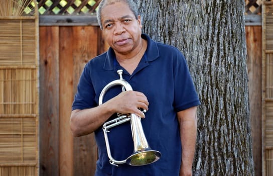 African american jazz musician with his flugelhorn outside.