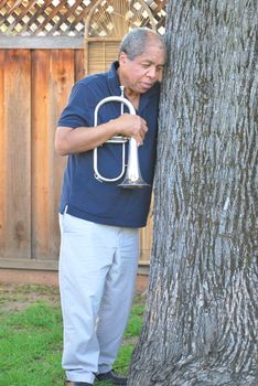 African american jazz musician with his flugelhorn outside.