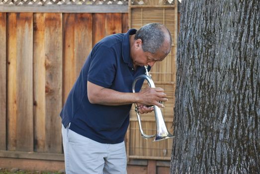 African american jazz musician with his flugelhorn outside.